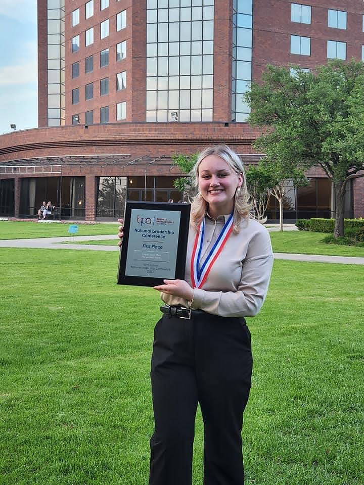 FIXED-holdingaward Girl holding an award plaque.