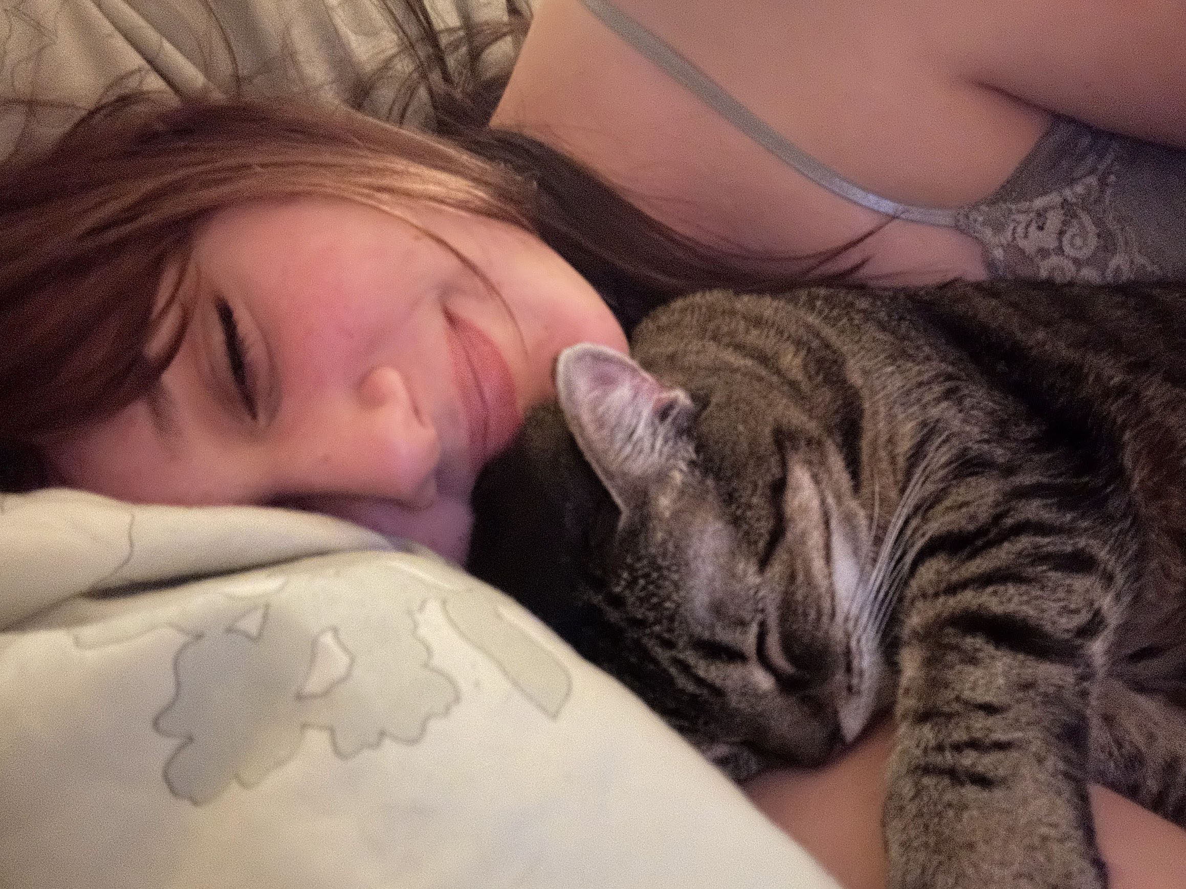 FIXED-layingwithcat Girl cuddling with a small cat.